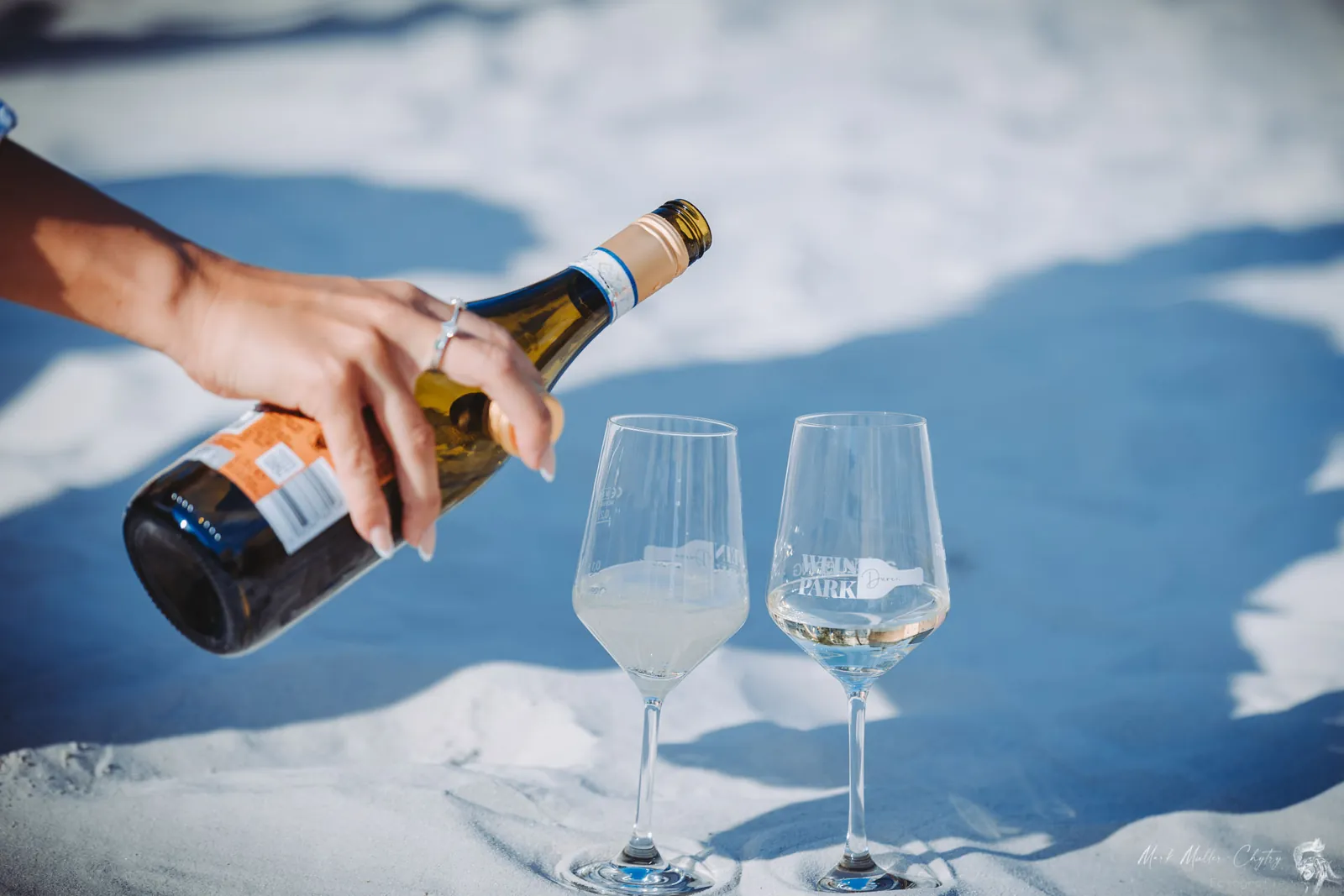 Wein wird frisch in Gläser im Sand eingeschenkt